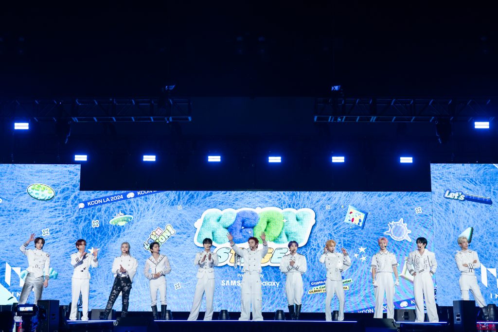 スクリーンの前にたつINIのメンバー、池﨑理人、尾崎匠海、木村柾哉、後藤威尊、佐野雄大、許豊凡、髙塚大夢、田島将吾、西洸人、藤牧京介、松田迅